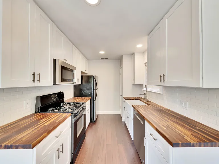 Modern Kitchen: featuring beautiful butcher block countertops, crisp white shaker style cabinets, and sleek stainless steel appliances.