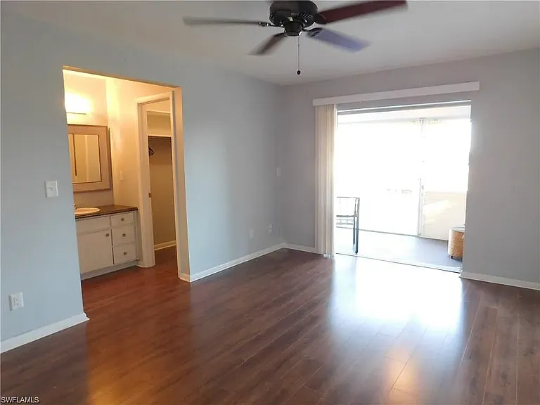 Another view of primary bath looking toward the bathroom area and spacious closet.