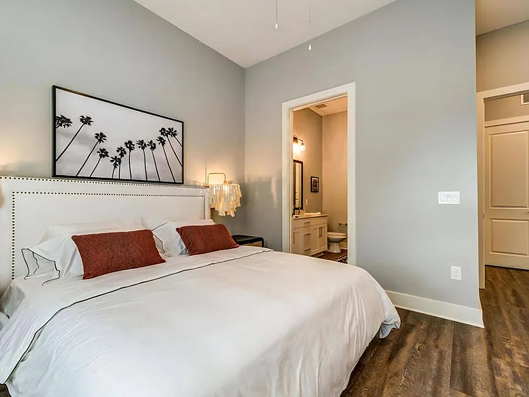 Modern Bedroom with Large Layout, Statement Lighting, and Private Bath Entrance