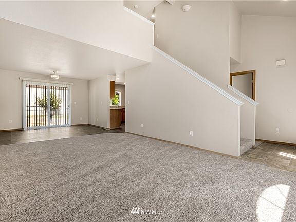 The living room flows freely into the large dining area.  High vaulted ceilings add to the spacious feel of this home.