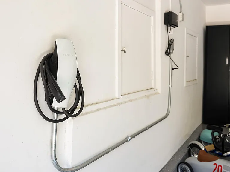 Charge your Tesla effortlessly with the convenient car charger in the garage.
