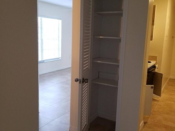 Dining room closet facing kitchen and hallway to BR and BA