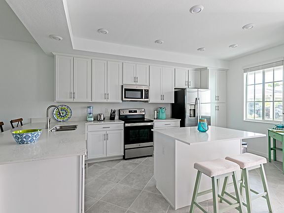 Beautiful, open kitchen stocked with all of the pots, pans, plates, and utensils you need to prepare meals.