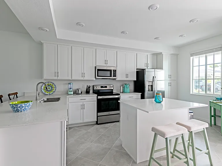 Beautiful, open kitchen stocked with all of the pots, pans, plates, and utensils you need to prepare meals.