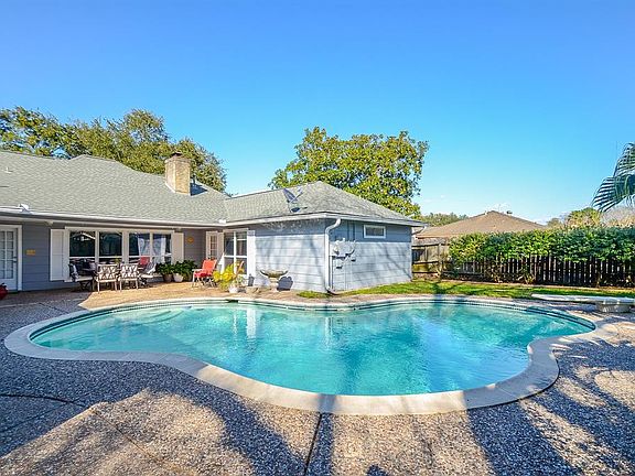 Backyard with large patio with a built-in fence to the driveway. Large Pool.