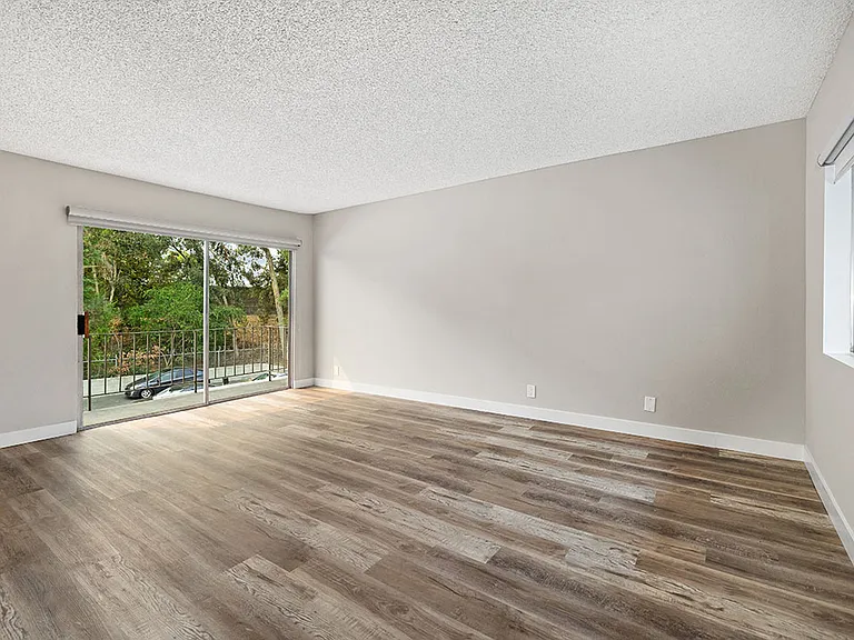 Hardwood floored bedroom with direct balcony access.