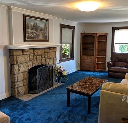 Living room with furniture and a wood burning fireplace.