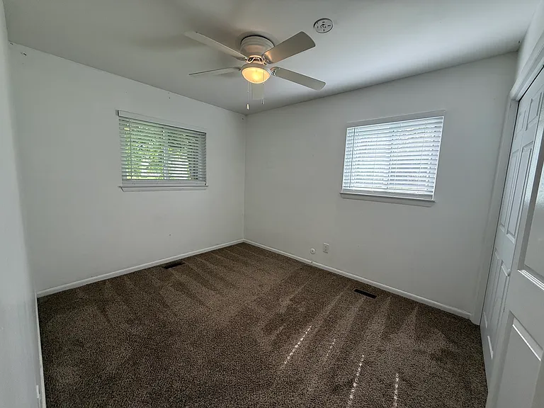 Corner Bedroom, view from entry door, left window overlooks Crab Apple St, right window overlooks side yard