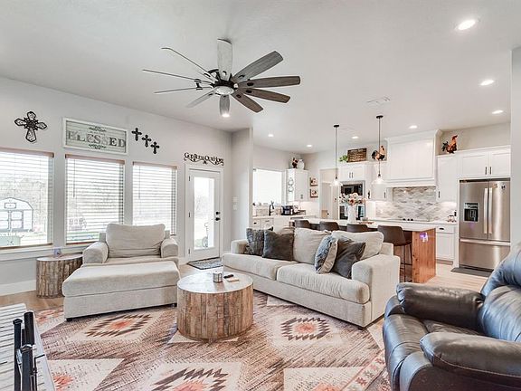 Living room featuring ceiling fan and light hardwood / wood-style flooring