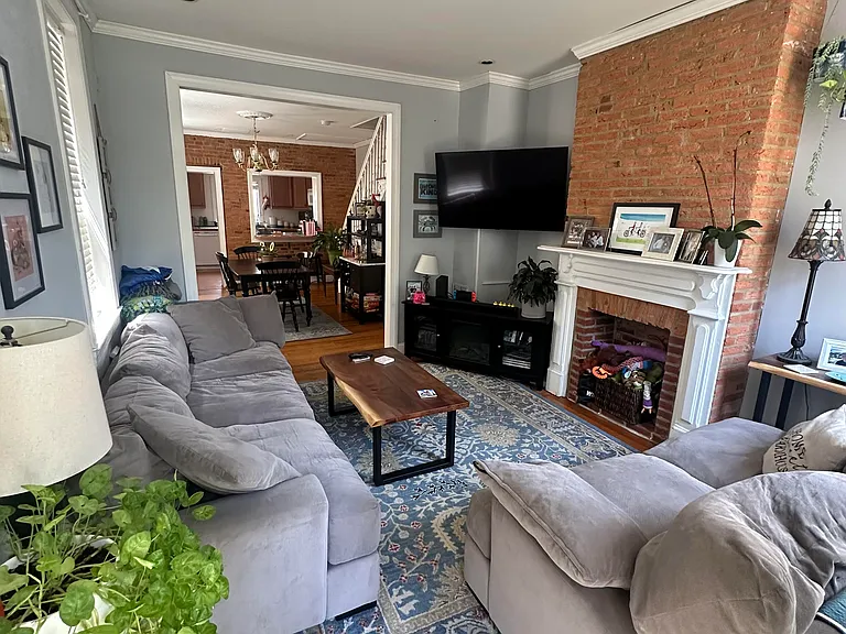 Living room view to dining room, original historic mantel, 2024