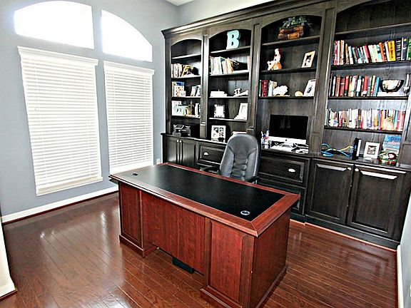 ENJOY WORKING FROM HOME IN THE STUDY WITH HARDWOOD FLOORS, CUSTOM BUILT-IN BOOKSHELVES AND FILING CABINET