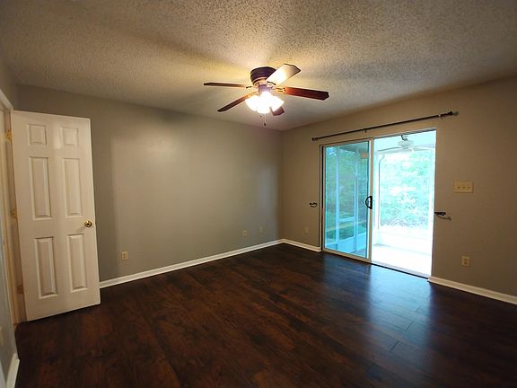 master bedroom with private bath, walk-in closet, and sliding doors to the screened porch