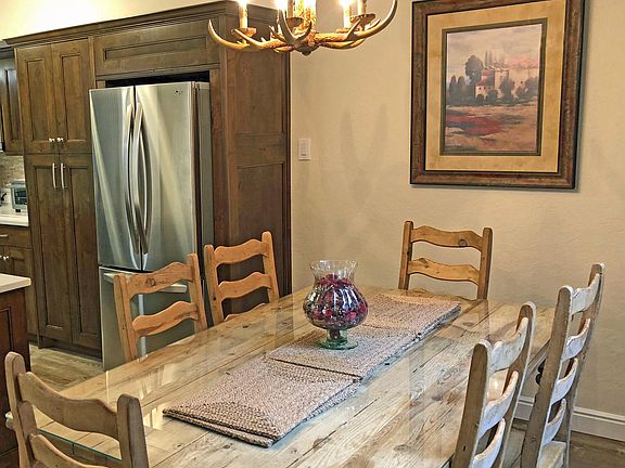 This is the dining area shown and part of the kitchen, with a stainless steel French Door LG refrigerator.