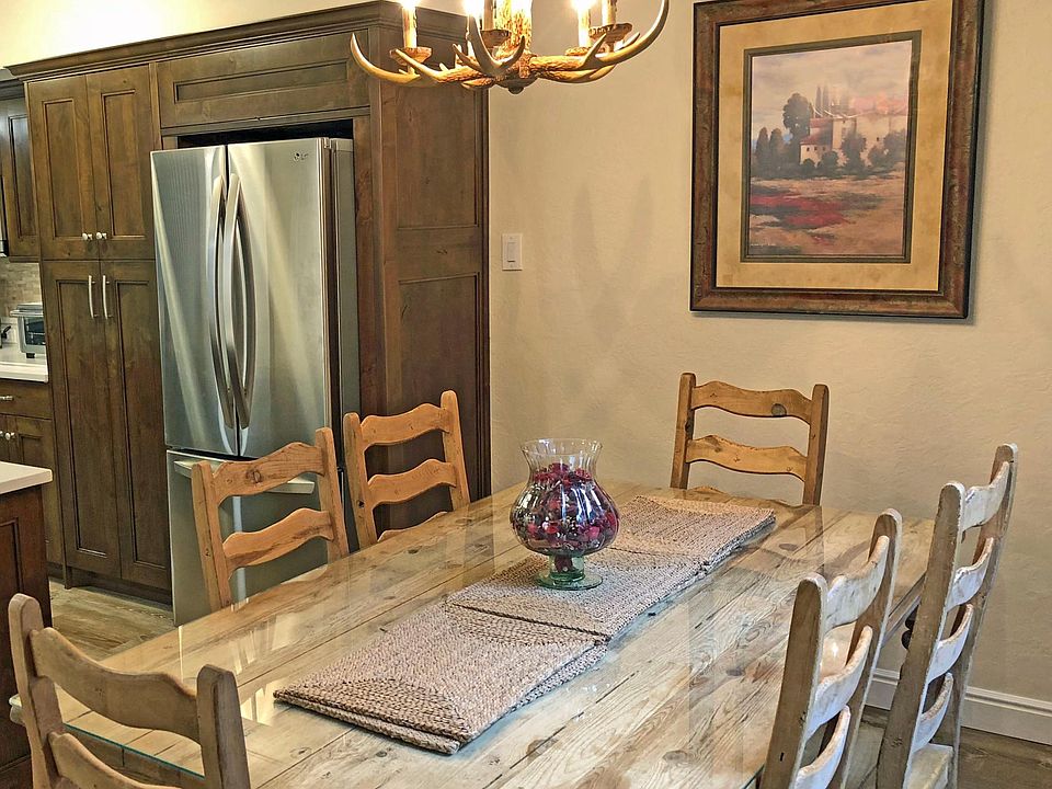 This is the dining area shown and part of the kitchen, with a stainless steel French Door LG refrigerator.