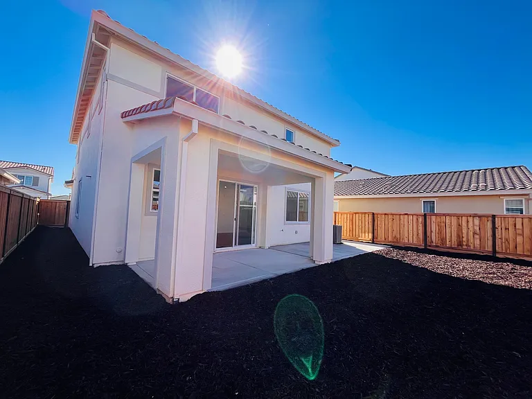 Backyard with extended concrete and low maintenance mulch