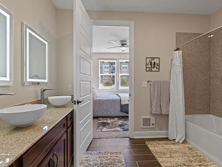 Dual vanities with vessel bowl sinks and LED backlit mirrors