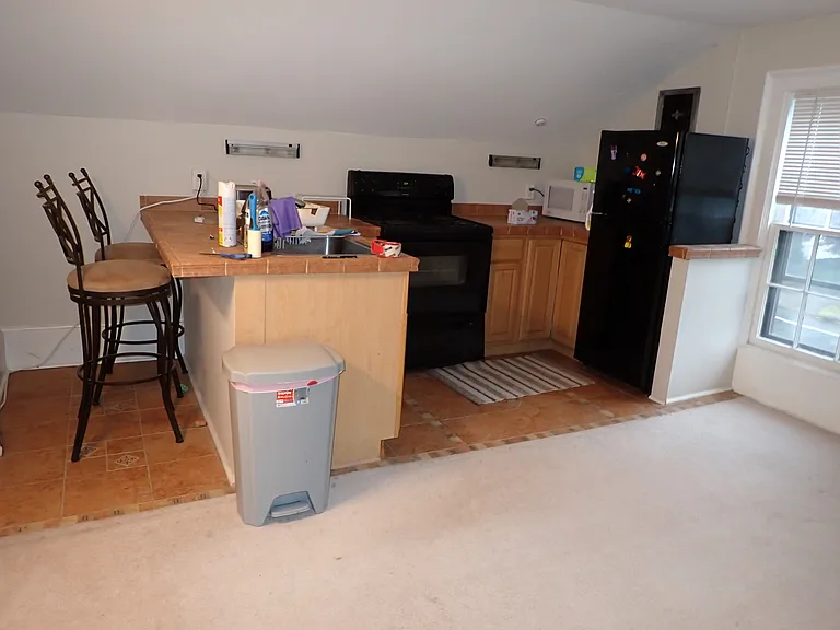 kitchen area off living room. 2 stools come with rental. all tiled floor and counter.
