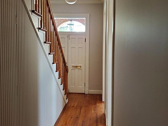 Entry foyer shows the high ceilings and hardwood throughout the space.