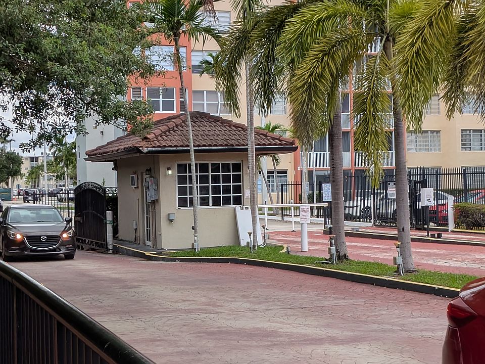 Gated community entrance with booms and guard house.