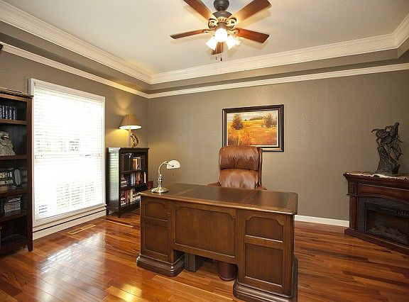 Office withwood floor and cove ceiling.