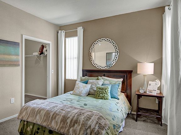 A bedroom with a large closet and windows overlooking the property