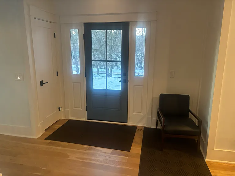 Front door at base of staircase. Open to dining room and living space.