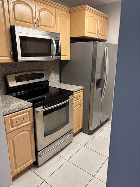 Kitchen (left side) includes stainless steel finished oven/stove, microwave and refrigerator with convenient ice/water dispenser.