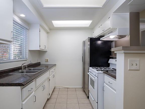 Quaint kitchen with stove and refrigerator