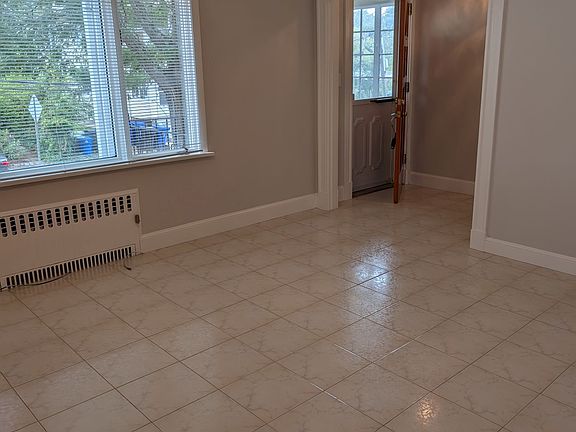 Living room with ceiling fan and tile floor.
