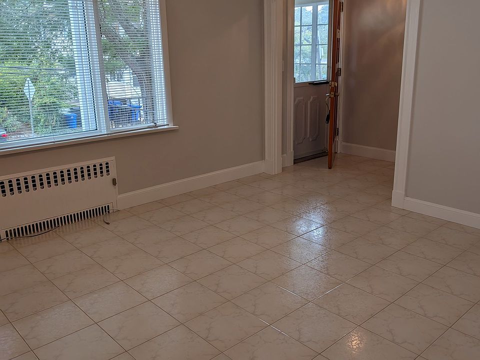 Living room with ceiling fan and tile floor.