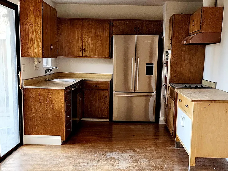 Kitchen. New countertops being installed. Sliding glass door to back yard.