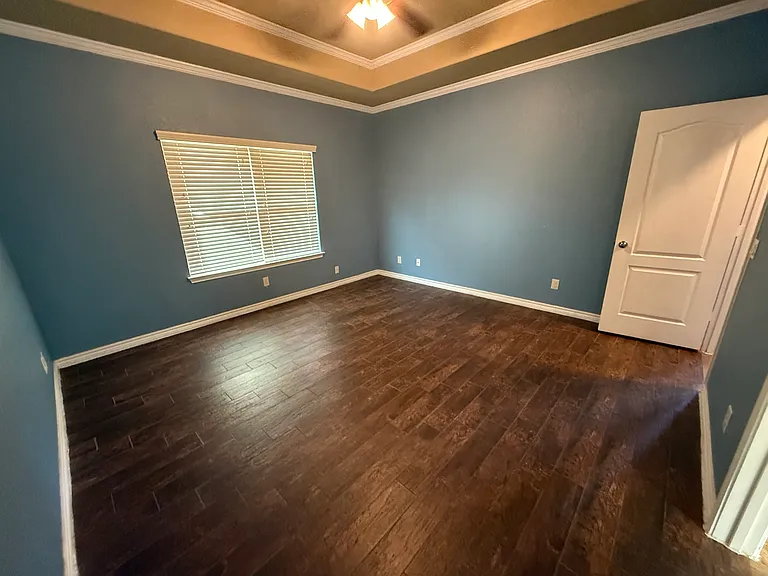 1st level bedroom is the largest bedroom in the house the ceramic wood style tile will look beautiful with any custom bedroom furniture and rugs.