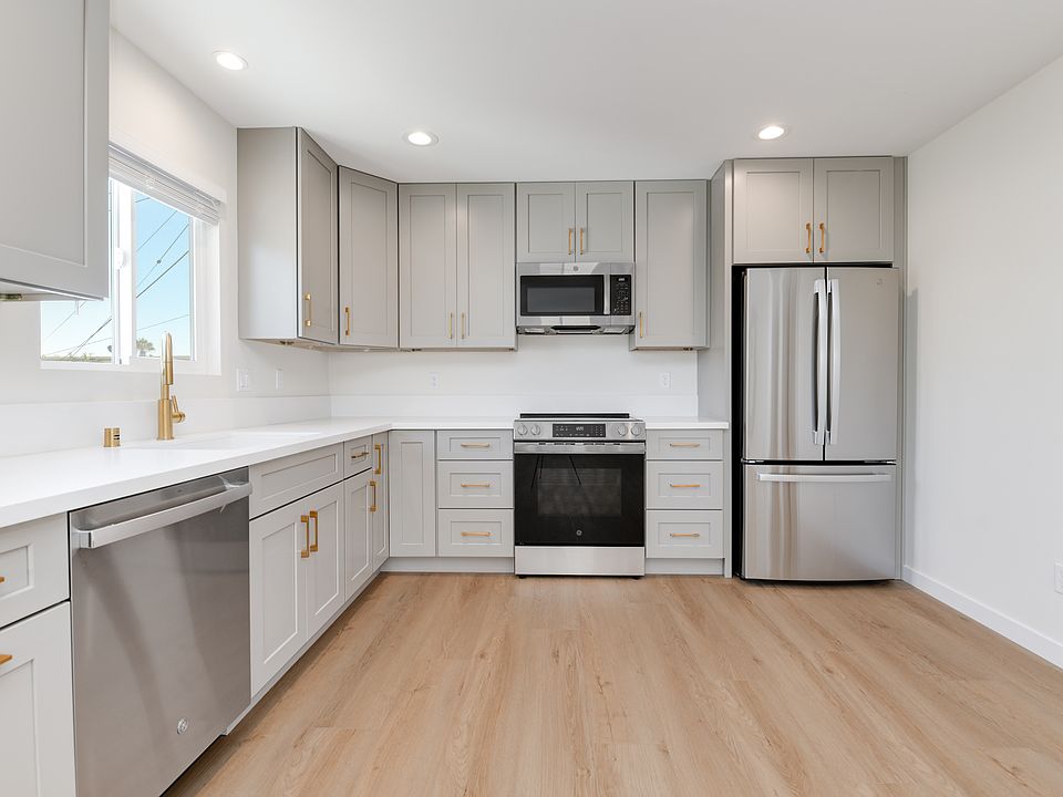 New stainless GE appliances throughout, including an electric cooktop and dishwasher. Large pantry cabinet, granite composite sink, with semi-custom cabinetry and brass finishes.