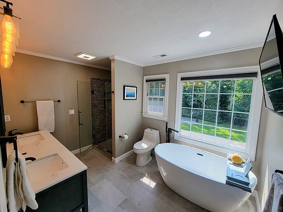 Completely renovated primary bath with new custom tile, dual vanity with storage, new custom window treatments, soaking tub & tv.