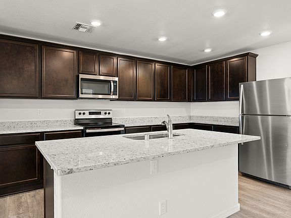 Designer kitchen with a large granite island and stainless appliances.