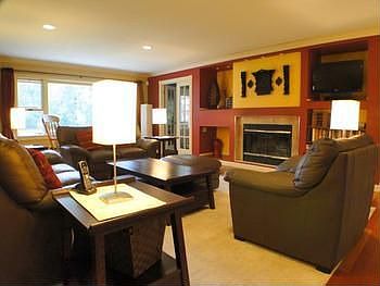 Living room with gas fireplace, beautiful wood flooring and a great view!