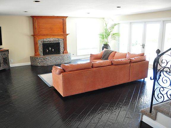 Living room with doors out to the patio offering seating in the front yard with ocean views, gas fireplace, TV and sectional sofa.