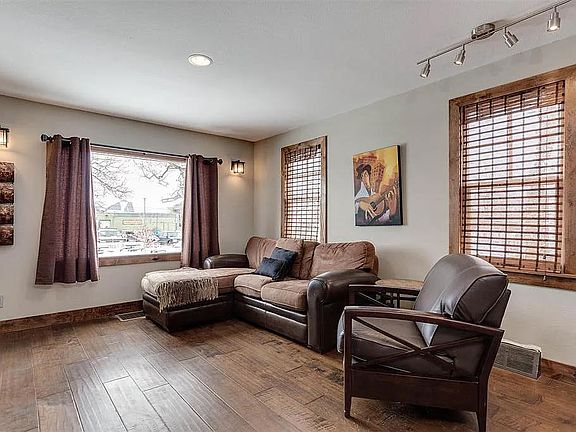 Living room shows off hardwood floors. You can check the new snow on the Bridgers from the big picture window. Furnishing includes sofa and dining table. (Different model than pictured here).