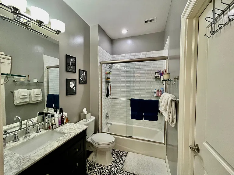 Newly Renovated Bathroom w/ Heavy Glass Enclosed Shower Doors, Large Vanity and Designer Tile. New Lighting Installed.