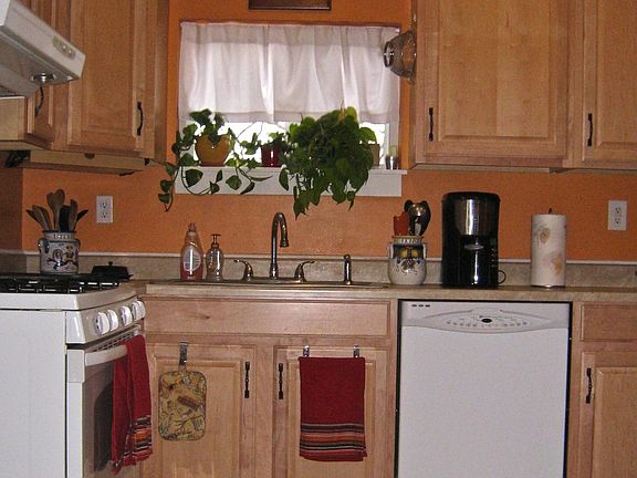 Spacious updated kitchen with maple cabinets and tile flooring.