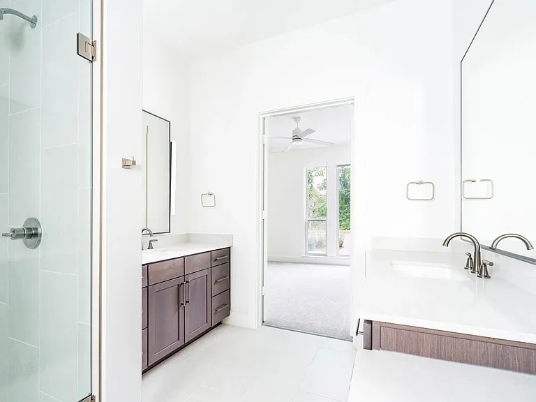 Primary bathroom showcasing one of multiple finish options, with a quartz vanity, wood-toned cabinetry, and a glass-enclosed shower tailored to your preferences.