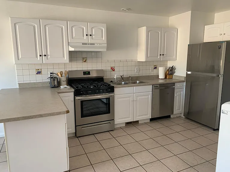 Brand new refrigerator, stove, faucet, and dish washer in kitchen.