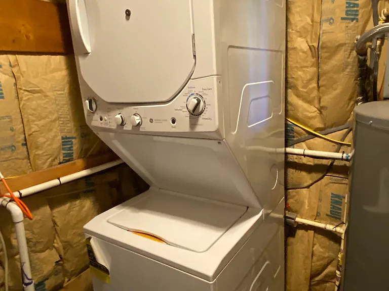 Stacked washer and dryer across from front door