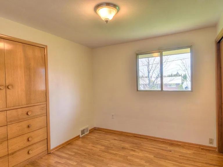 Bedroom with built-in drawers and shelving. New energy efficient window treatments not in picture.