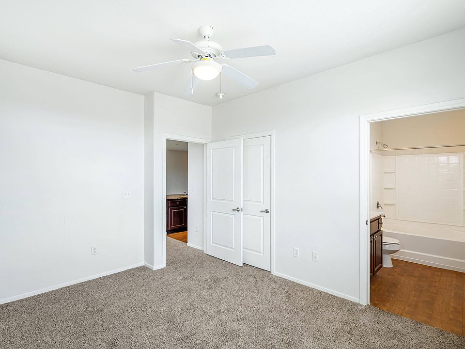 Enhance your space with the simplicity and freshness of a bedroom adorned with pristine white walls and a sleek ceiling fan, providing both style and comfort