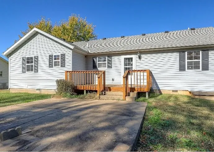 Back of house showing deck and concrete patio