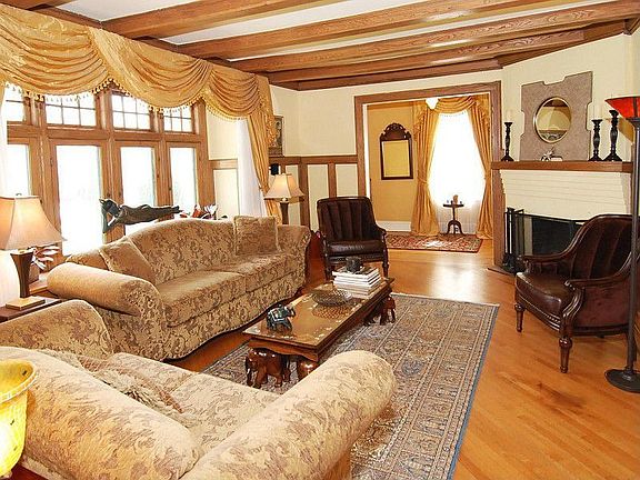 LIVING ROOM WITH BOX BEAM CEILINGS, WOOD-BURNING FIREPLACE & BAY WINDOWS