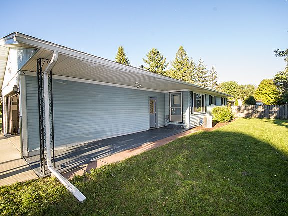 View of the patio area and a portion of the expansive back yard. The door on the back of the home leads to the patio, convenient for those summer cook outs or for peaceful nights watching the sun set on your own piece of paradise. 