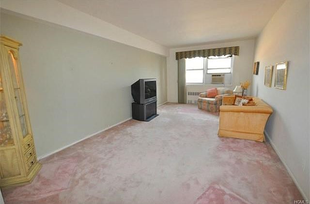 Large living room with covered hardwood floors.