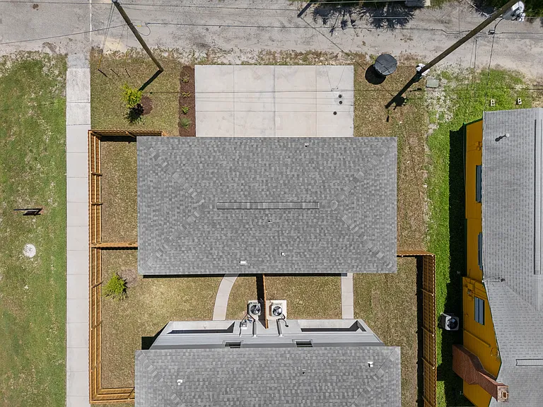 505 1/2 aerial showing the driveway to a private carport and fully fenced backyard perfect for small pets.